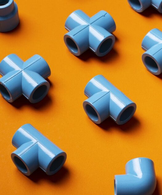 blue pieces of new pvc pipe on orange background